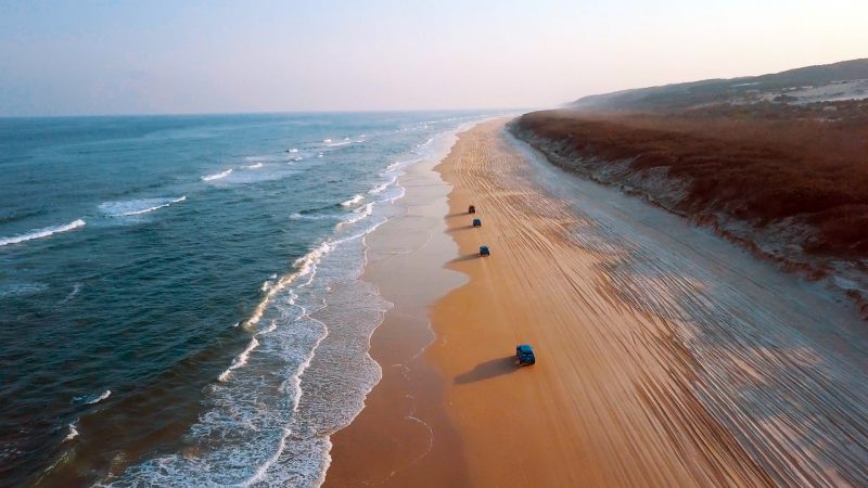 Adventure trucks driving along Fraser island beach